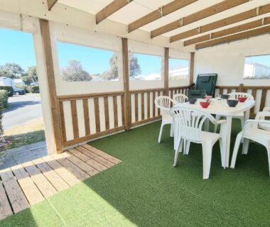 Terrasse couverte avec table et chaises au mobil home tout confort dans parc résidentiel de loisirs