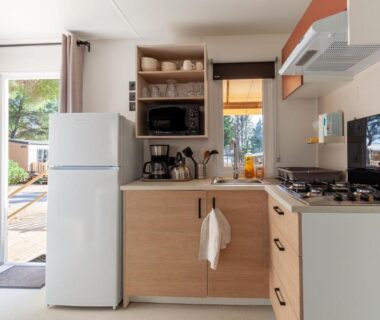 Cuisine équipée avec réfrigérateur micro-ondes et plaque de cuisson dans le mobil home tout équipé