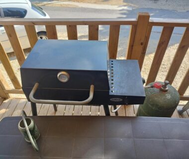 Terrasse avec barbecue à gaz table et bouteille de gaz du Mobil home tout équipé
