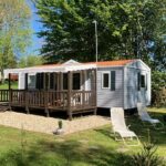 Emplacement herbeux avec mobil-home terrasse et chaises longues au Mobil homes 6 et 8 places Camping de Bairon 08