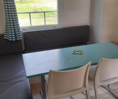 Coin repas intérieur avec banquette et table dans le mobil home Mobil homes 6 et 8 places Camping de Bairon