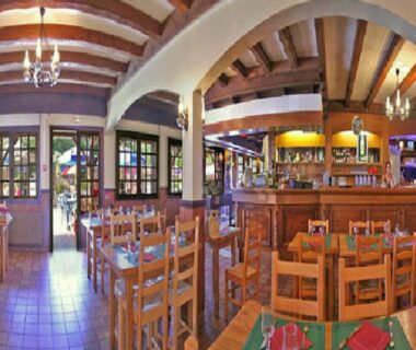 Salle à manger intérieure avec tables en bois et bar aux Mobil-homes proche de l’océan