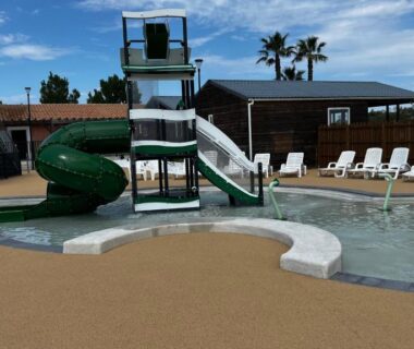 Aire aquatique avec toboggan vert pataugeoire et transats au Mobil homme proche de la mer