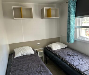 Chambre avec deux lits simples et table de chevet dans le MobilHome 6 pers du camping ACM