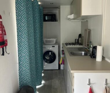 Cuisine intérieure avec lave-linge micro-ondes et évier dans le MobilHome 6 pers 3 ch tout équipé au camping ACM
