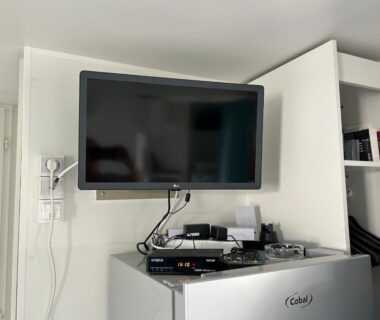 Coin séjour avec télévision murale et mini réfrigérateur dans le MobilHome 6 pers