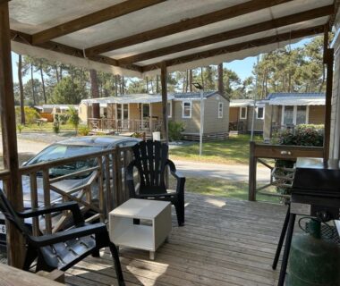 Terrasse couverte avec chaises et barbecue donnant sur mobilhomes du MobilHome 6 pers