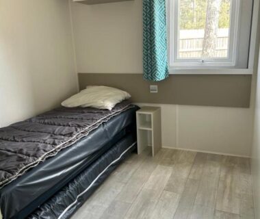 Chambre avec lit simple et fenêtre dans le MobilHome 6 pers 3 ch tout équipé camping ACM