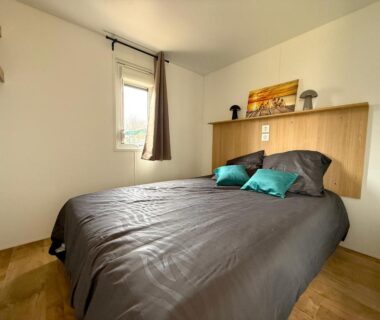 Chambre double avec lit et fenêtre dans le MobilHome de la Coccinelle