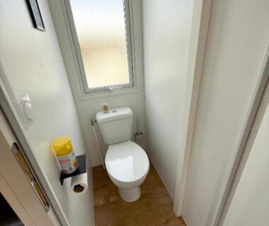 WC avec fenêtre et sol en bois dans le MobilHome de la Coccinelle