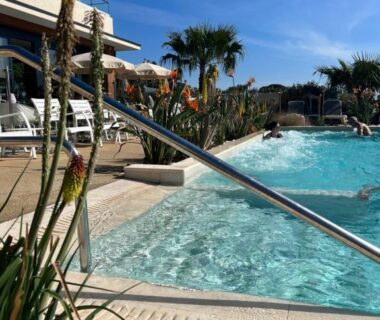 Bord de piscine ensoleillé avec transats et palmiers au Mobile Evasion okpl BEAUVOIR