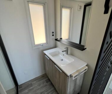 Salle de bain avec lavabo miroir et fenêtre dans le mobil-home Mobile Evasion okpl BEAUVOIR