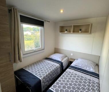 Chambre avec deux lits simples et fenêtre dans le mobile home 168 du Camping Siblu Lac des Rêves Perols