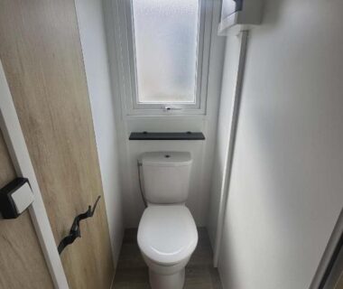 Toilettes étroites avec WC sous fenêtre dans le Mobile Home 8 personnes