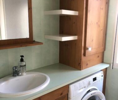 Salle d'eau avec lavabo et lave-linge dans le mobile home du Camping Le Dattier