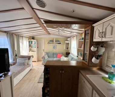 Séjour avec canapé et kitchenette dans le mobile home du Camping Le Dattier