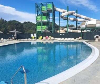 Piscine extérieure avec toboggans et chaises longues au Mobile Home Climatisé 3 chambres à Narbonne Plage