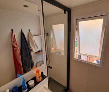 Salle de bains avec lavabo miroir fenêtre dans le Mobile Home La Roulotte Catalane