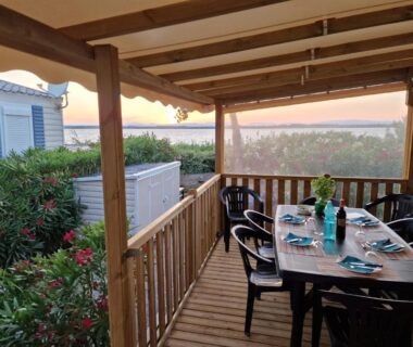Terrasse couverte avec table et chaises dans le Mobile Home La Roulotte Catalane