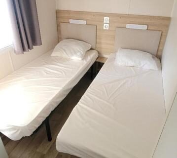 Intérieur avec deux lits simples dans le Mobile Home La Roulotte Catalane