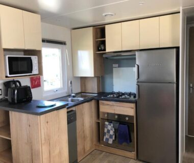Cuisine équipée avec réfrigérateur et plaque de cuisson dans le mobile home Les Dunes de Contis