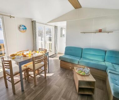 Salon lumineux avec coin repas et baie vitrée dans le Mobile Home Luca