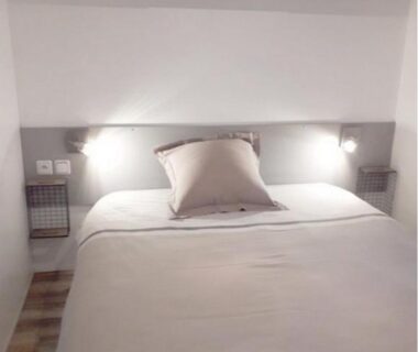 Chambre double avec éclairage mural et rangements dans le Mobile Home Service Hotelier