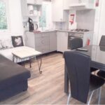 Séjour avec coin cuisine canapé et table dans le Mobile Home Service Hotelier