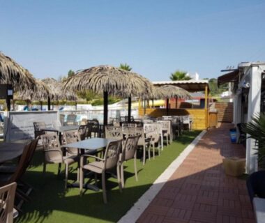 Terrasse piscine avec tables et parasols au Mobile Home Service Hotelier