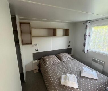 Chambre avec lit double et serviettes pliées dans le Mobile Home XL Camping 5 étoiles