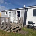 Terrasse en bois avec chaises et barbecue du Mobile Home XL Camping 5 étoiles