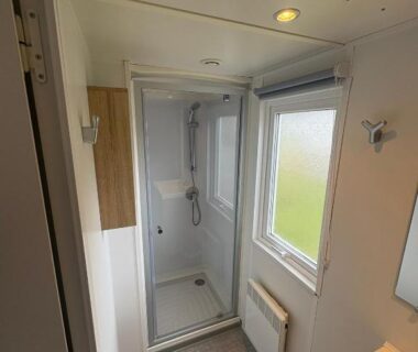 Salle de bain avec cabine de douche lavabo et fenêtre dans le Mobile Home XL Camping 5 étoiles