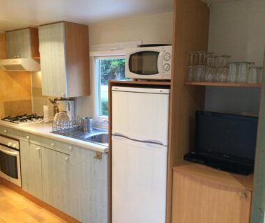 Cuisine équipée avec réfrigérateur micro-ondes et four dans le Mobile Home à Louannec