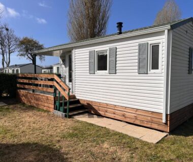 Façade et petite terrasse sur pelouse du Mobile Home à Louannec