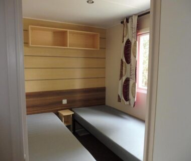Chambre avec deux lits simples dans le Mobile Home bois dormant