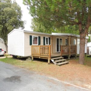 Emplacement de camping avec terrasse en bois et arbres du Mobile Home bois dormant