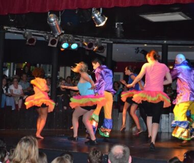 Scène intérieure avec danseurs en costumes colorés au Mobile Home bois dormant