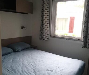 Chambre intérieure avec lit double et fenêtre dans le Mobile Home du Domaine de Kerlann
