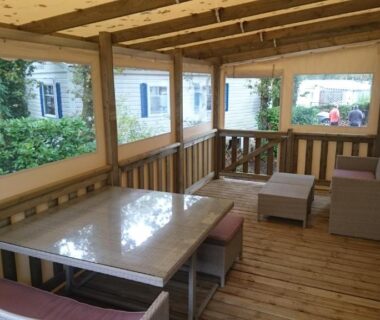 Terrasse couverte avec coin repas et salon du mobile home dans le Domaine de Kerlann