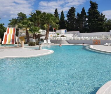 Piscine extérieure avec toboggan et transats au Mobile Home tout confort Séléna