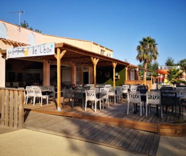 Terrasse couverte avec tables et chaises au camping Mobile Homes Sous le Soleil