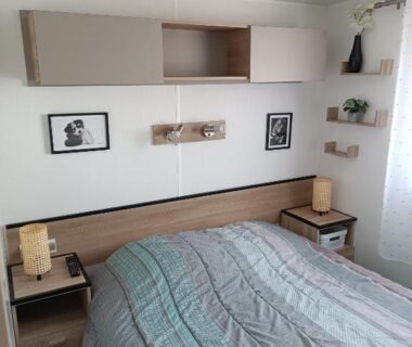 Chambre avec lit double lampes chevets et étagères dans le mobile home Mobile Homes Sous le Soleil