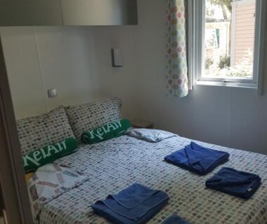 Chambre avec lit double et serviettes dans le Mobile Homes by KelAir at Camping Sylvamar