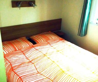 Chambre avec lit double et fenêtre du mobile home