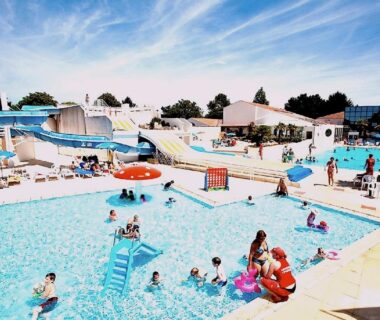 Piscine extérieure avec toboggans et baigneurs au Mobile home