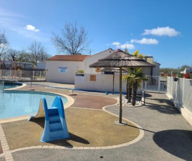 Piscine extérieure avec toboggan et parasol au mobile home
