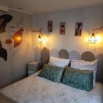 Chambre avec lit double coussins et lampes murales dans le Mobile home