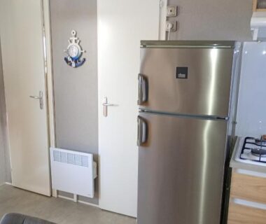 Intérieur coin cuisine avec réfrigérateur et portes du Mobile home