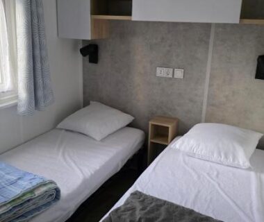 Chambre avec deux lits et rangements du Mobile home 4 a 6 personnes Domaine de Kerlann
