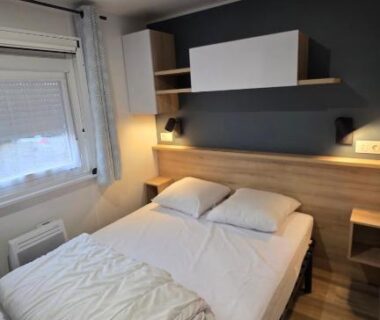 Chambre avec lit double et lampe de chevet dans le mobile home Domaine de Kerlann